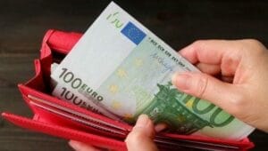 Mujer pagando las tarifas de un Gigoló con billetes de 100 euros
